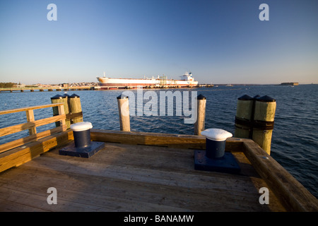 An oil tanker being unloaded just beyond a public pier. Stock Photo