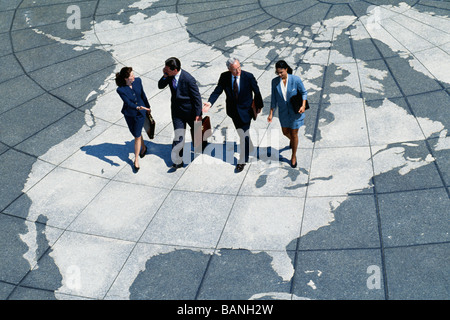 Businesspeople walking on map of globe Stock Photo
