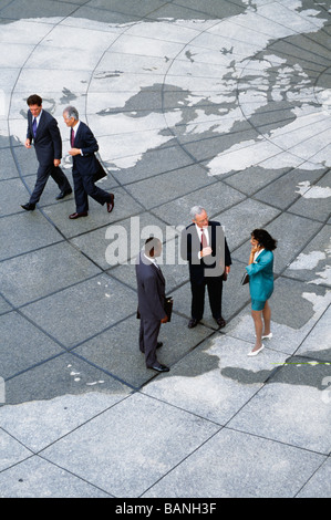 Businesspeople standing on map of globe Stock Photo