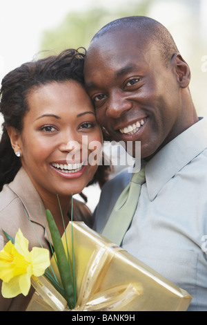 African couple hugging and holding gift Stock Photo - Alamy