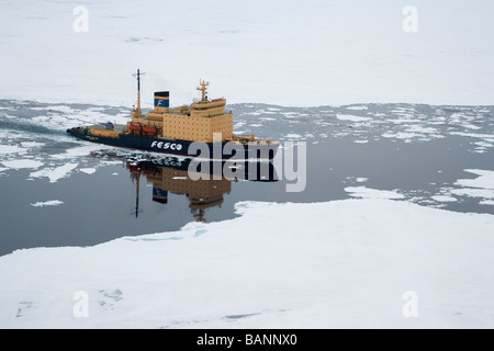 Icebreaker ship cruising through Ice Flows of West Admunson Sea Antarctica reflected in calm waters of open leads open white space Stock Photo