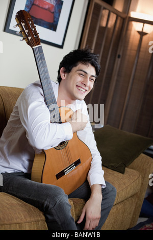 Mixed race man holding guitar Stock Photo