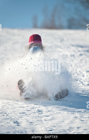 going down tobogganing hill with lots of snow flying Stock Photo