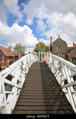 Woman standing on tip toe looking over the Arched wooden Footbridge on the River Great Ouse at Godmanchester Cambridgeshire UK Stock Photo