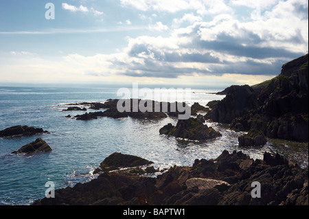 harsh sunlight,clouds and rocks on Ballycotton Bay, Co.Cork, Ireland Stock Photo