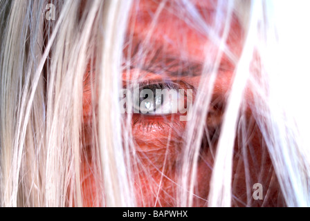 Middle aged man looking with one eye through long unkempt hair. Stock Photo