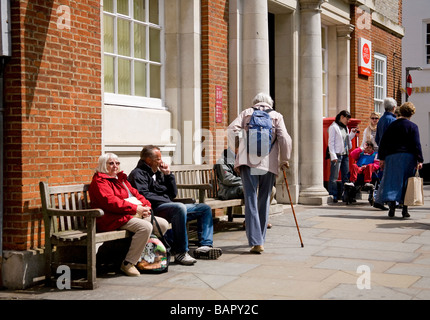 Old lady with walking stick outside Post Office, Chichester, UK Stock Photo