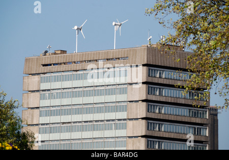 Wind turbines on top of nineteen sixties concrete office building Stock Photo