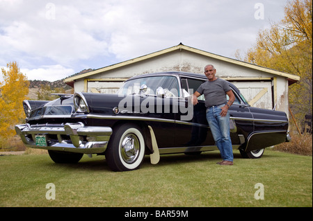 Portrait of elderly man with his antique 1955 Mercury automobile at his home in the small town of Salida Colorado USA Stock Photo