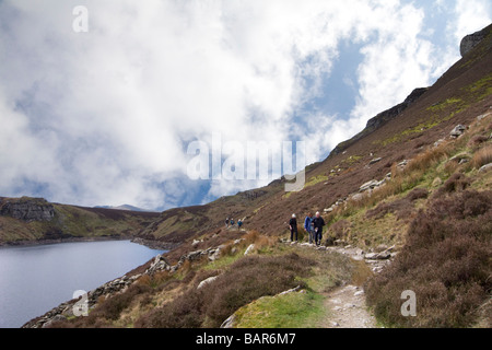 Capel Curig Conwy North Wales UK April Group of walkers  on footpath alongside Llyn Cowlyd Reservoir in Carneddau Mountains  Snowdonia National park Stock Photo