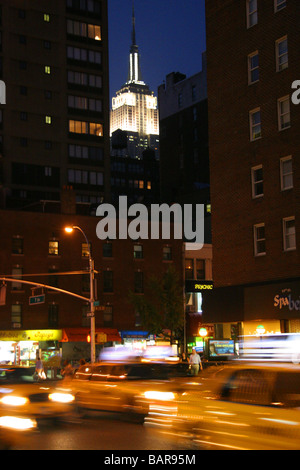 Yellow taxi cabs and the Empire State Building at night New York City Stock Photo