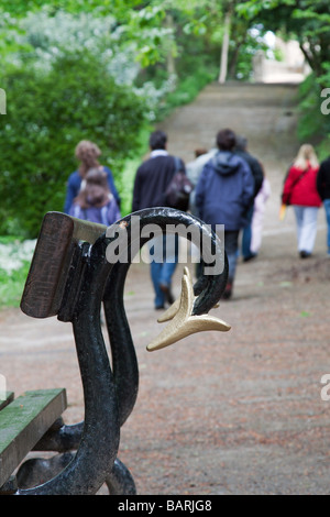 Group of young people walking along a path away from a park bench Stock Photo