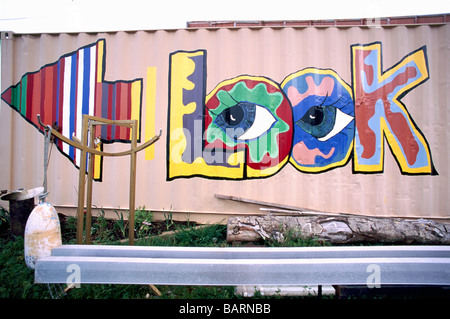 Colorful Look Graffiti Art Information Sign with Arrow pointing in Left Direction painted on Exterior Side Wall of a Building Stock Photo