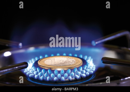 Flame of gas stove and Euro coin, close-up Stock Photo