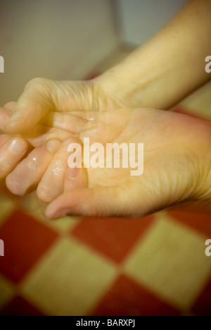 A woman washes her hands with and antiseptic hand cleaning gel Stock Photo
