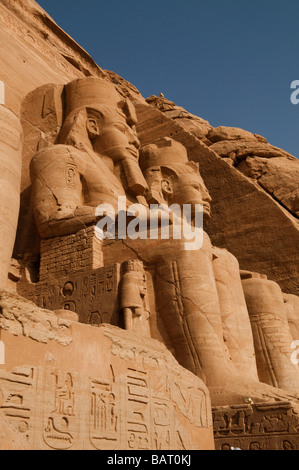 The massive four colossal statues of Pharaoh decorating entrance to the Sun Temple Of Ramses II in Abu Simbel rock temples. Southern Egypt Stock Photo