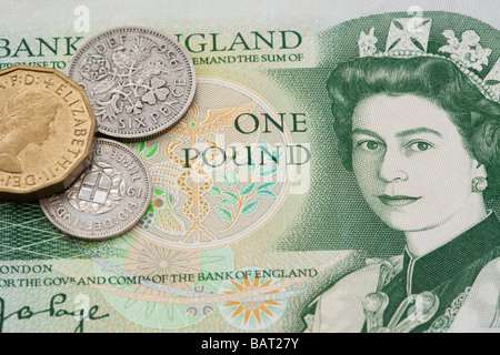 Old British one pound note with pre-decimal imperial coins in close up. England, UK, Britain Stock Photo