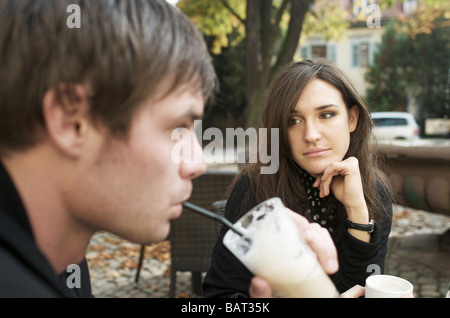 Young woman looking at her boyfriend at an outdoors café Stock Photo