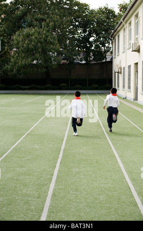 School children racing down a school yard during a physical fitness class. Stock Photo