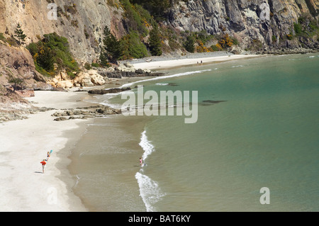 Families on Beach by Doctors Point viewed from Mapoutahi Historic Maori Pa Site north of Dunedin South Island New Zealand Stock Photo