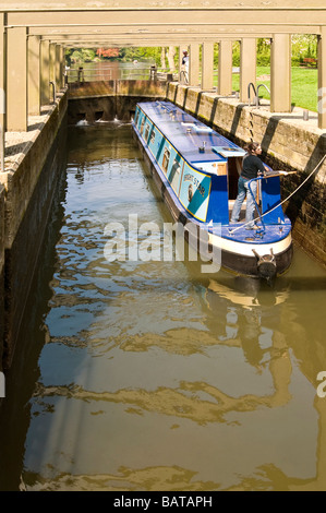 Vertical wide angle of a traditional narrowboat inside the chamber of a filling lock on the River Avon on a sunny day Stock Photo