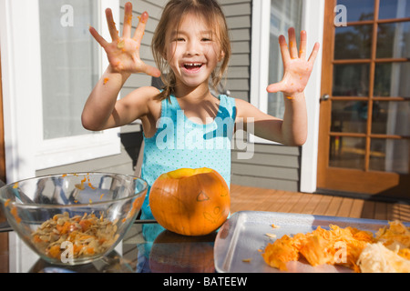 Mixed race young girl preparing Halloween pumpkin Stock Photo