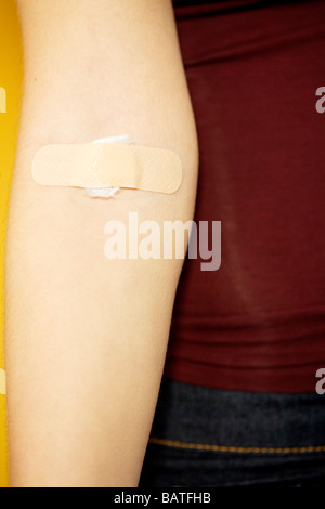 band-aid on a young woman's arm Stock Photo