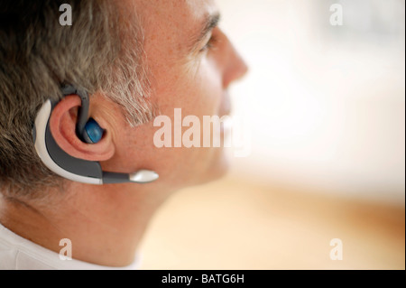 Wireless communication. Man wearing a mobile phone headset. Stock Photo