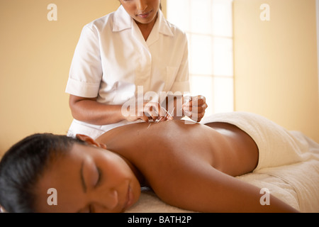 Acupuncture. Acupuncturist inserting a needle into a client's back. Stock Photo
