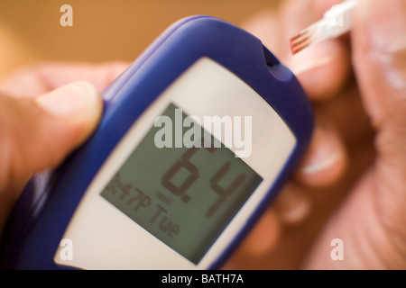 Blood glucose testing.This machine uses a small blood sample to test a patient. Stock Photo
