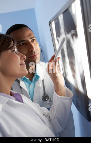 Radiologists studying an X-ray of a patient's hands. Stock Photo