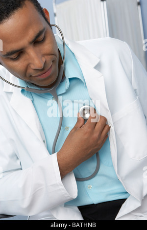 Doctor listening to his heartusing a stethoscope, a medical device that is usedto listen to sounds within the body. Stock Photo