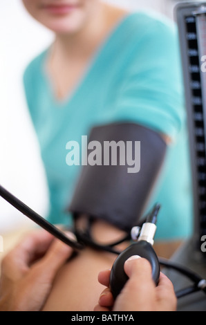 Blood pressuremeasurement. Sphygmomanometer and stethoscopebeing used by a doctor to measure a femalepatient Stock Photo