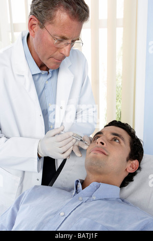 Botox treatment. Patient having botox injected into his face. Botox is a neurotoxin used for cosmetic purposes. Stock Photo