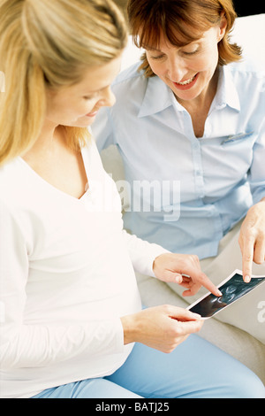 Obstetric examination. Midwife discussing sonogram with an expectant mother. Stock Photo