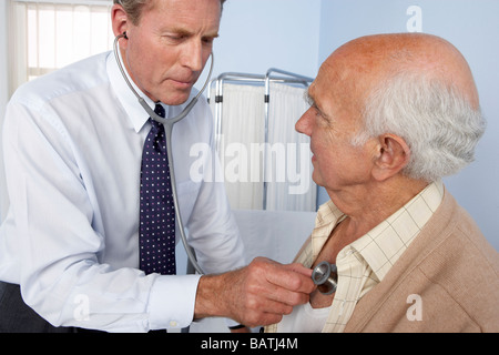 Medical consultation. General practitioner using a stethoscope to examine an elderly patient. Stock Photo