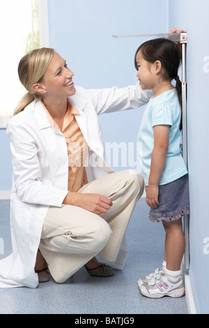 Child height measurement. Doctor measuring the height of a young girl during a check-up.