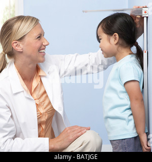 Child height measurement. Doctor measuring the height of a young girl during a check-up. Stock Photo