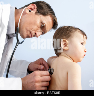 Paediatric examination. Doctor using a stethoscope to listen the heart and lung sounds of a one year old boy. Stock Photo
