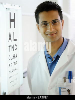 Optometrist next to an eyechart. The eye chart is used to test a person's visual acuity. Stock Photo