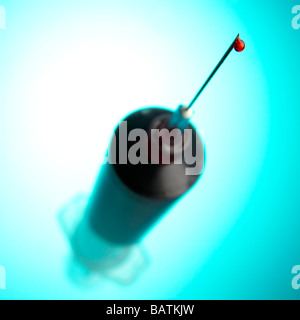 Blood filled syringe with a drop of blood on the tip of the needle. Stock Photo