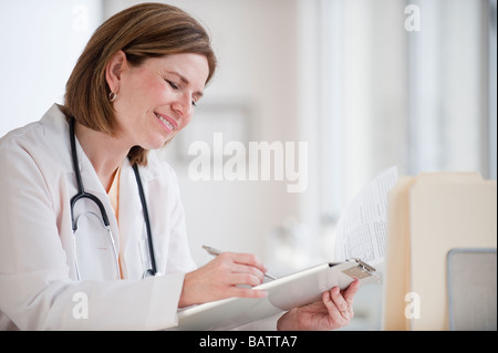 Female doctor writing on clipboard Stock Photo