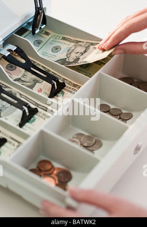Woman removing money from cash register, close-up Stock Photo