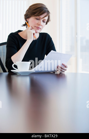 Mature businesswoman reading document Stock Photo