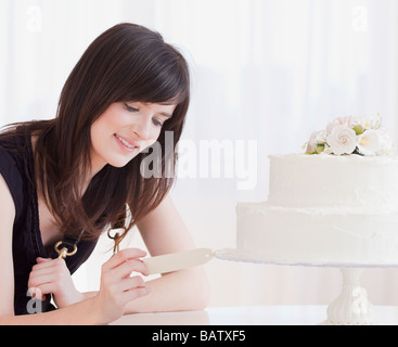 Young woman observing wedding cake, studio shot Stock Photo