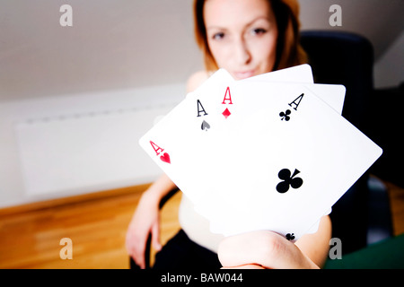 young woman with playing cards showing four aces Stock Photo