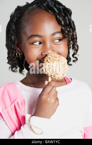 African girl eating candy apple Stock Photo