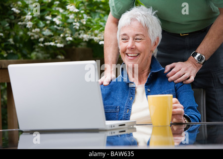 Senior couple looking at laptop outdoors Stock Photo