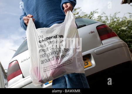 Shopper with cooperative supermarket Symphony Environmental biodegradable carrier bag UK Stock Photo