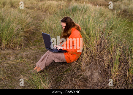 Girl using laptop in grass Stock Photo